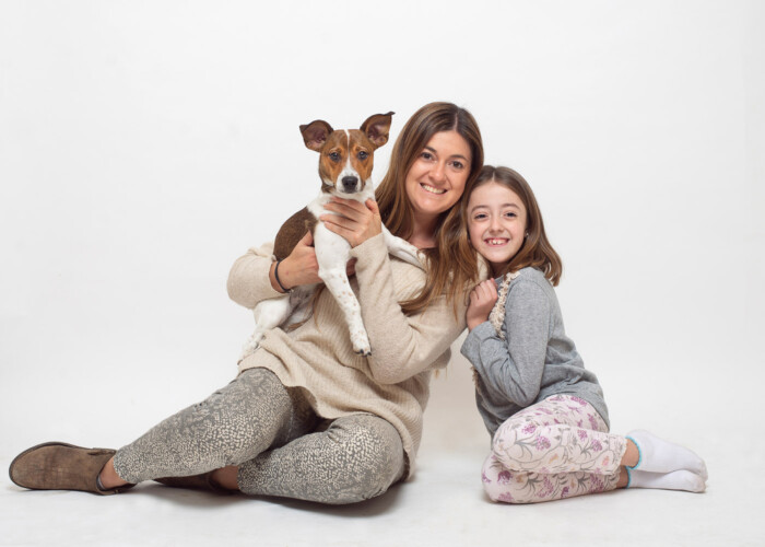 Dos mujeres sentadas con dos perros en un retrato de familia